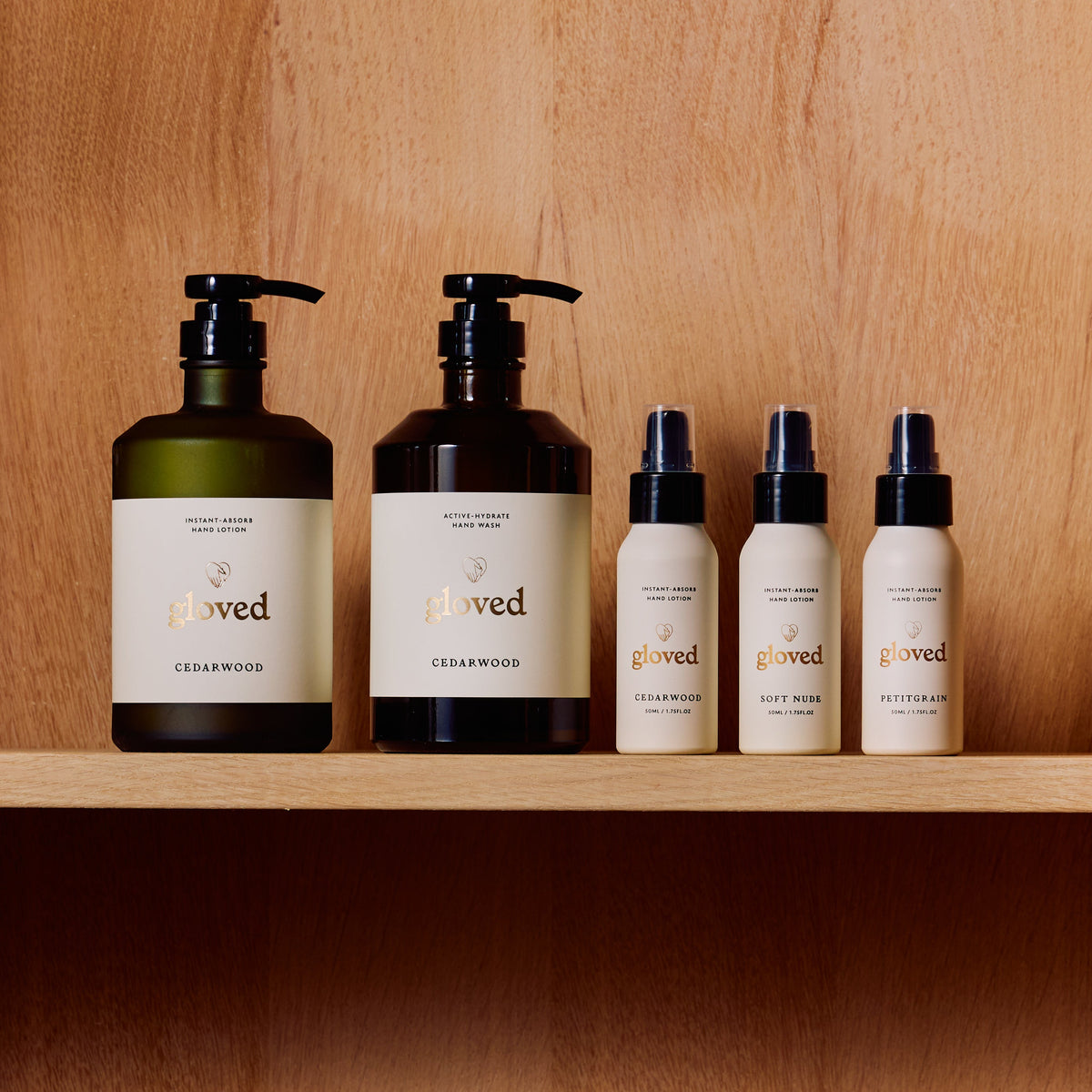 gloved hand wash, hand lotion and three mini lotions on a wooden shelf