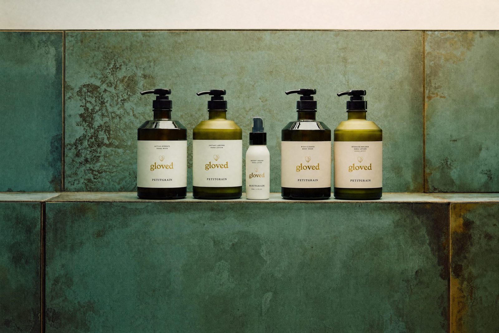 The five gloved essentials lined up on a green tiled shelf