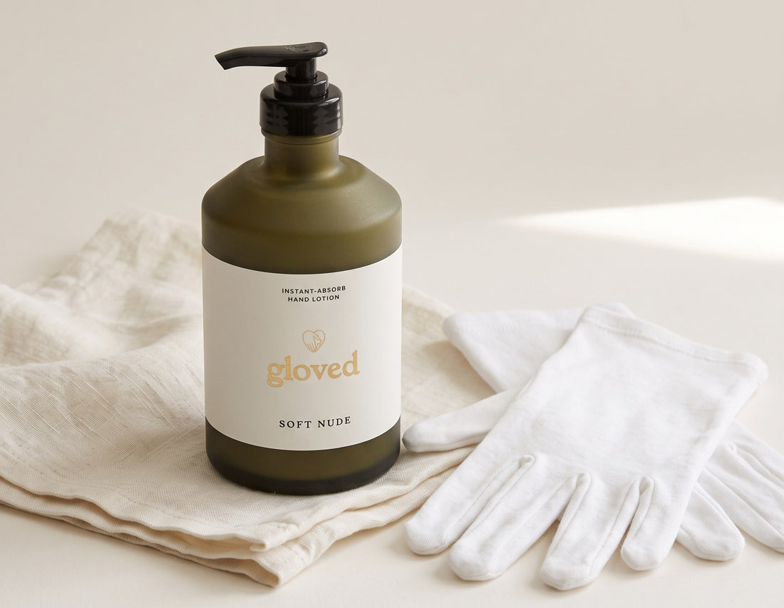 The gloved Instant-Absorb Hand Lotion on folded linen next to a pair of white cotton gloves
